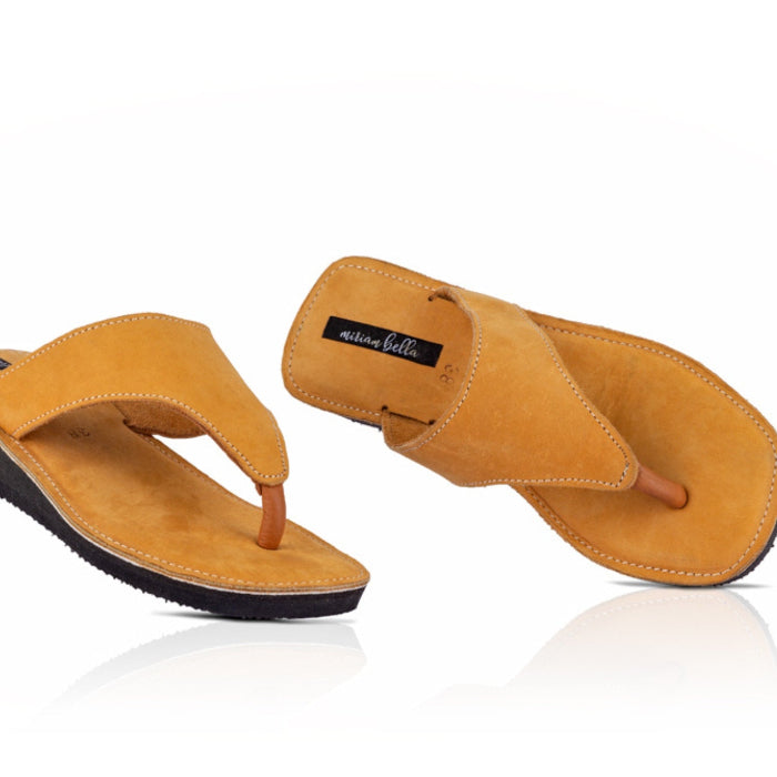 Pair of tan sandals with a brand label on a white background