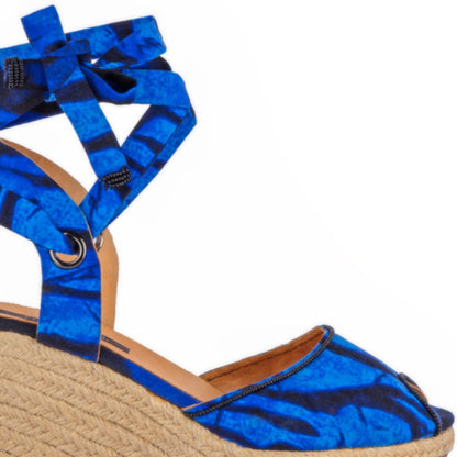 Blue espadrille wedge sandal with a strap on a white background