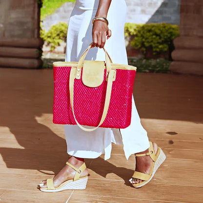 Person holding a red woven Tote Bag with ochre accents on a wooden floor.