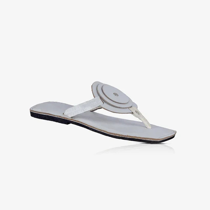 White ladies leather sandals with a unique circle detail and flat rubber sole.