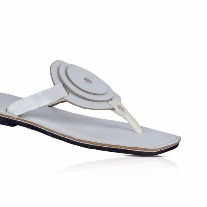 White sandal with a circular design on a white background