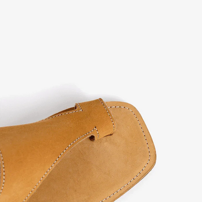 Close-up of a tan leathers sandal on a white background