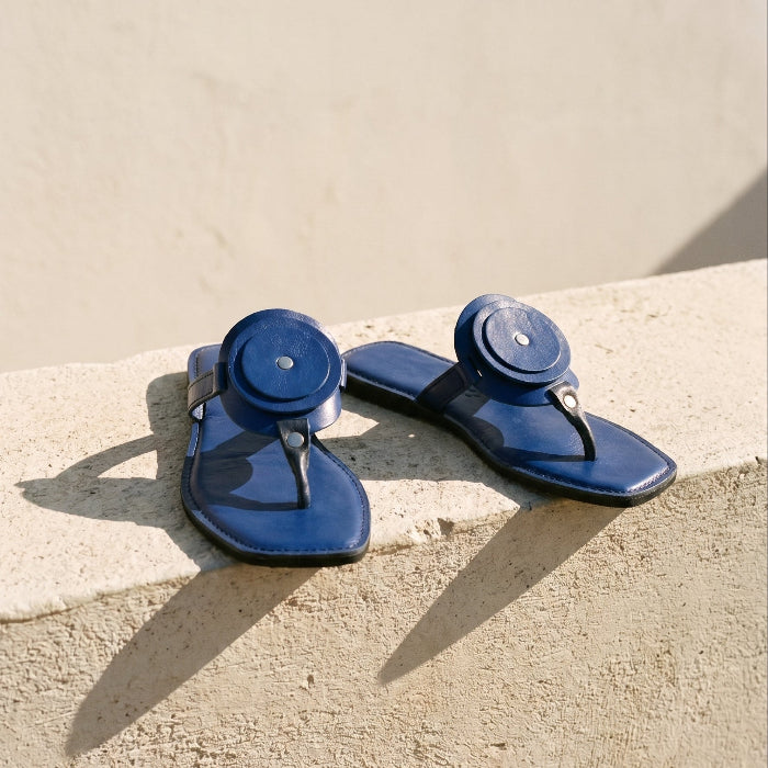 Pair of blue sandals on a beige surface