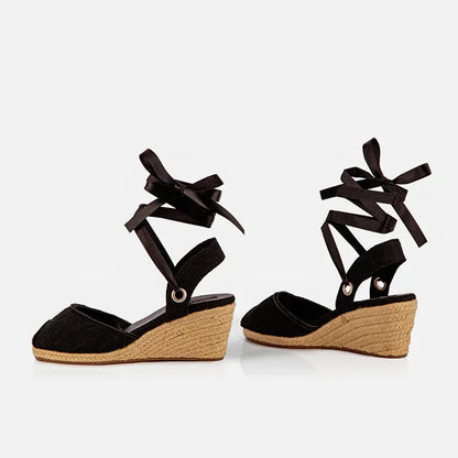 Gaia black canvas peep toe espadrille wedge heels shown at an angle with jute wedge and ribbon ties.