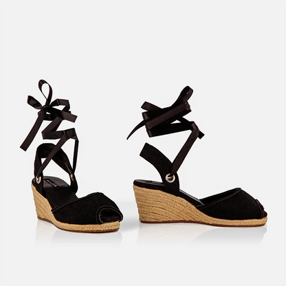 Side view of Gaia black canvas peep toe espadrille wedge heels with black ribbon ankle ties.
