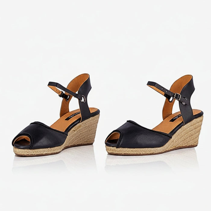 A pair of handcrafted leather black wedge espadrille sandals with jute sole by Miriam Bella on a white background.