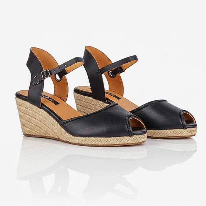 A pair of handcrafted leather black wedge espadrille sandals with jute sole by Miriam Bella on a white background.