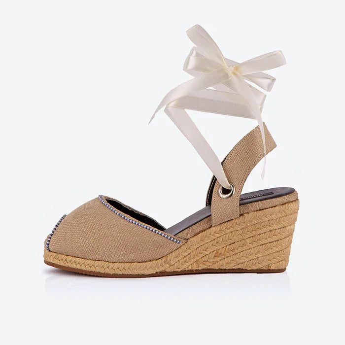 Single Gaia cream canvas closed toe espadrille wedge heel with white ribbon ankle ties and jute wedge.