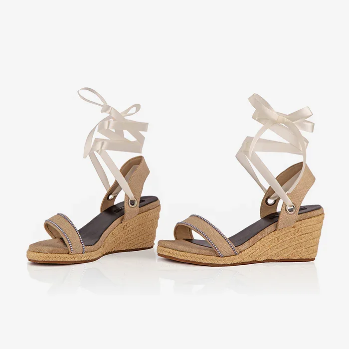 A pair of cream open-toed platform espadrilles with black straps and a wedge heel, featuring a  leather lining