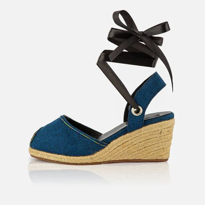 Single Gaia indigo canvas espadrille wedge heel with black ribbon ankle ties and jute wedge.