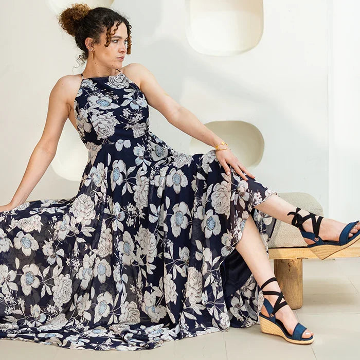 Gaia indigo canvas wedge espadrilles worn with black ribbon ankle ties and a floral dress.