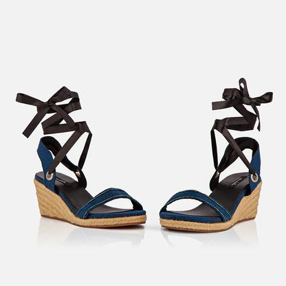 Front view of Gaia indigo canvas wedge espadrilles with open toe design and black ribbon ankle ties.