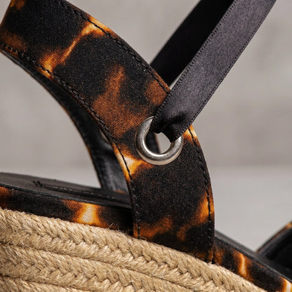 Close-up of a sGaia Midnight Flame espadrille wedge heels with black ankle ties on a neutral background