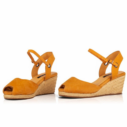 A pair of handcrafted leather ochre wedge espadrille sandals with jute sole by Miriam Bella on a white background.