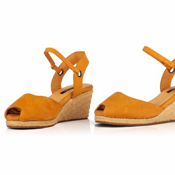 A pair of handcrafted leather ochre wedge espadrille sandals with jute sole by Miriam Bella on a white background.