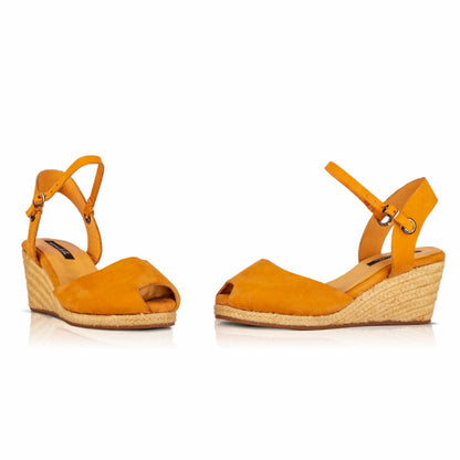A pair of handcrafted leather ochre wedge espadrille sandals with jute sole by Miriam Bella on a white background.