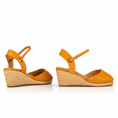 A pair of handcrafted leather ochre wedge espadrille sandals with jute sole by Miriam Bella on a white background.