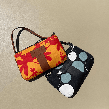 Two handbags, one with a floral pattern and the other with polka dots, on a beige background.
