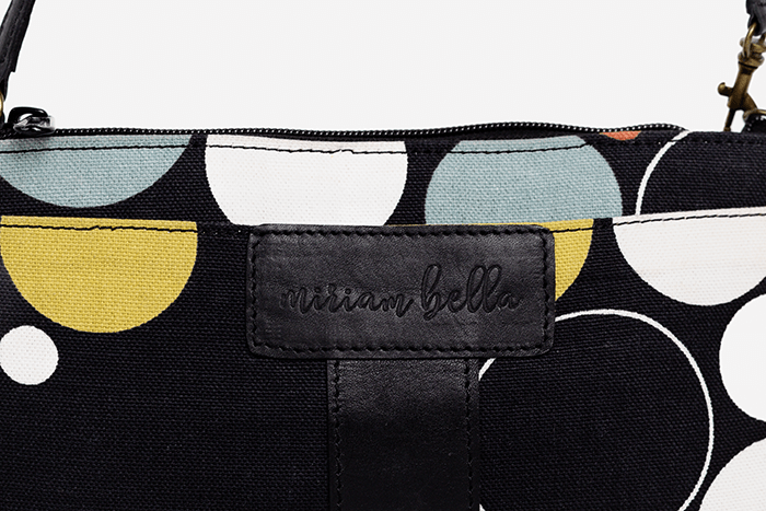 The Black Print Mini Tote Bag for Women, a Black pouch with geometric patterns and 'Miriam Bella' branding on a light gray background