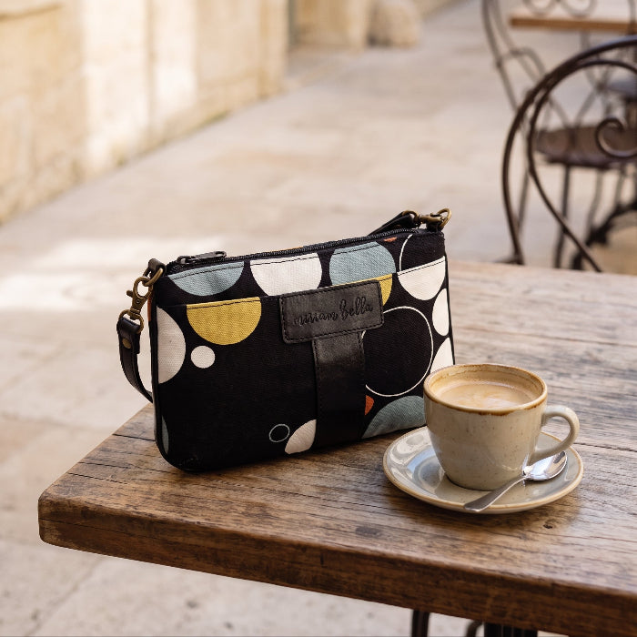 Black Print Mini Tote Bag for Women on a cafe table with a cup of coffee next to it.