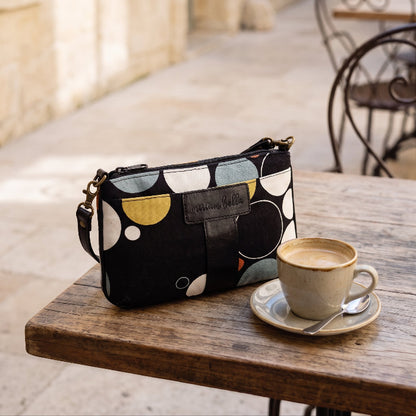 Black Print Mini Tote Bag for Women on a cafe table with a cup of coffee next to it.