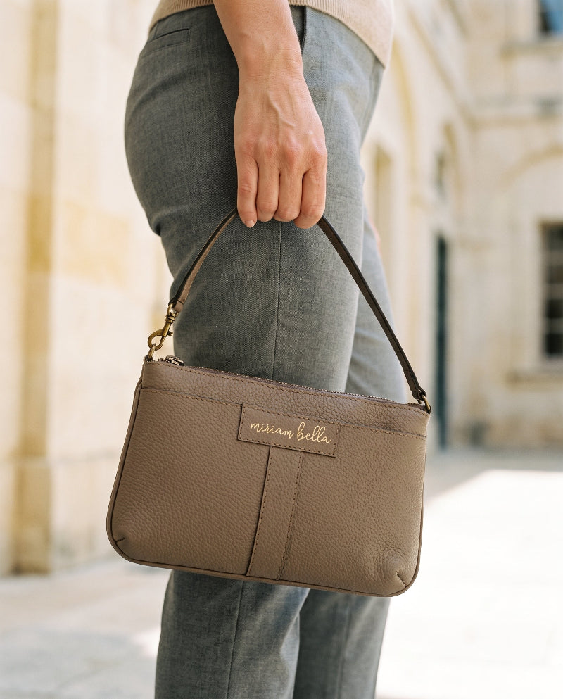 A woman holding the Mini Tote.
