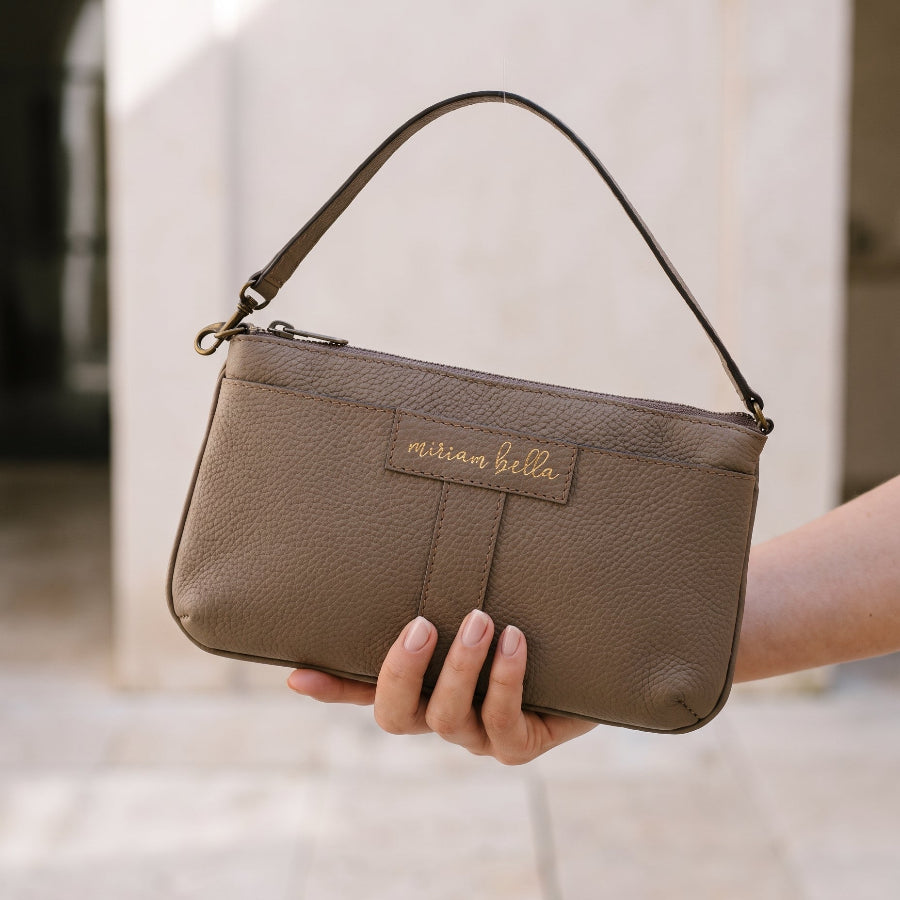 A hand holding the Mini Tote.