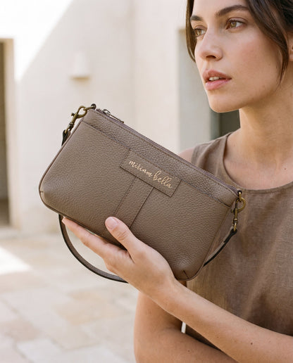 A woman holding the moss Mini Tote in her hand.