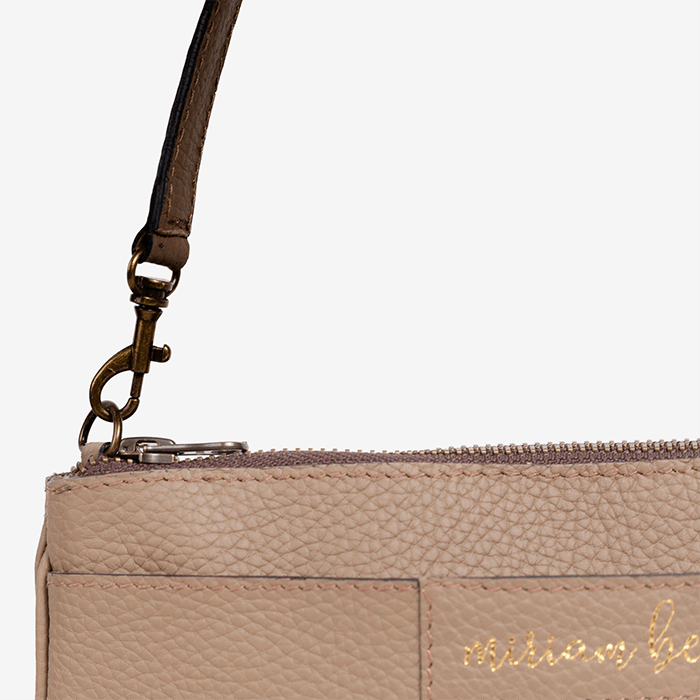 Close-up of the Mini Tote, a beige handbag with a strap and 'Miriam Bella' branding on a light gray background