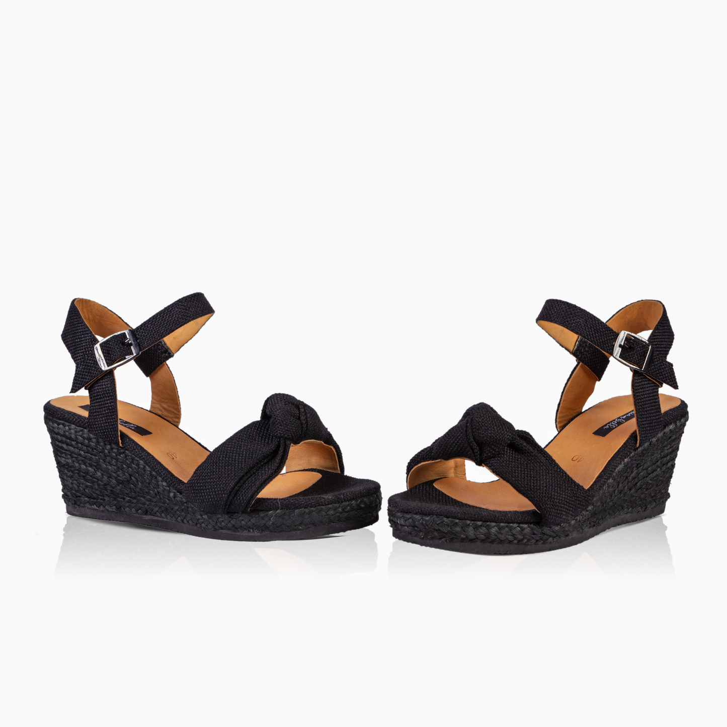 A pair of women's black wedge sandals with braided espadrille-style soles and adjustable ankle straps, shown on a clean white background.