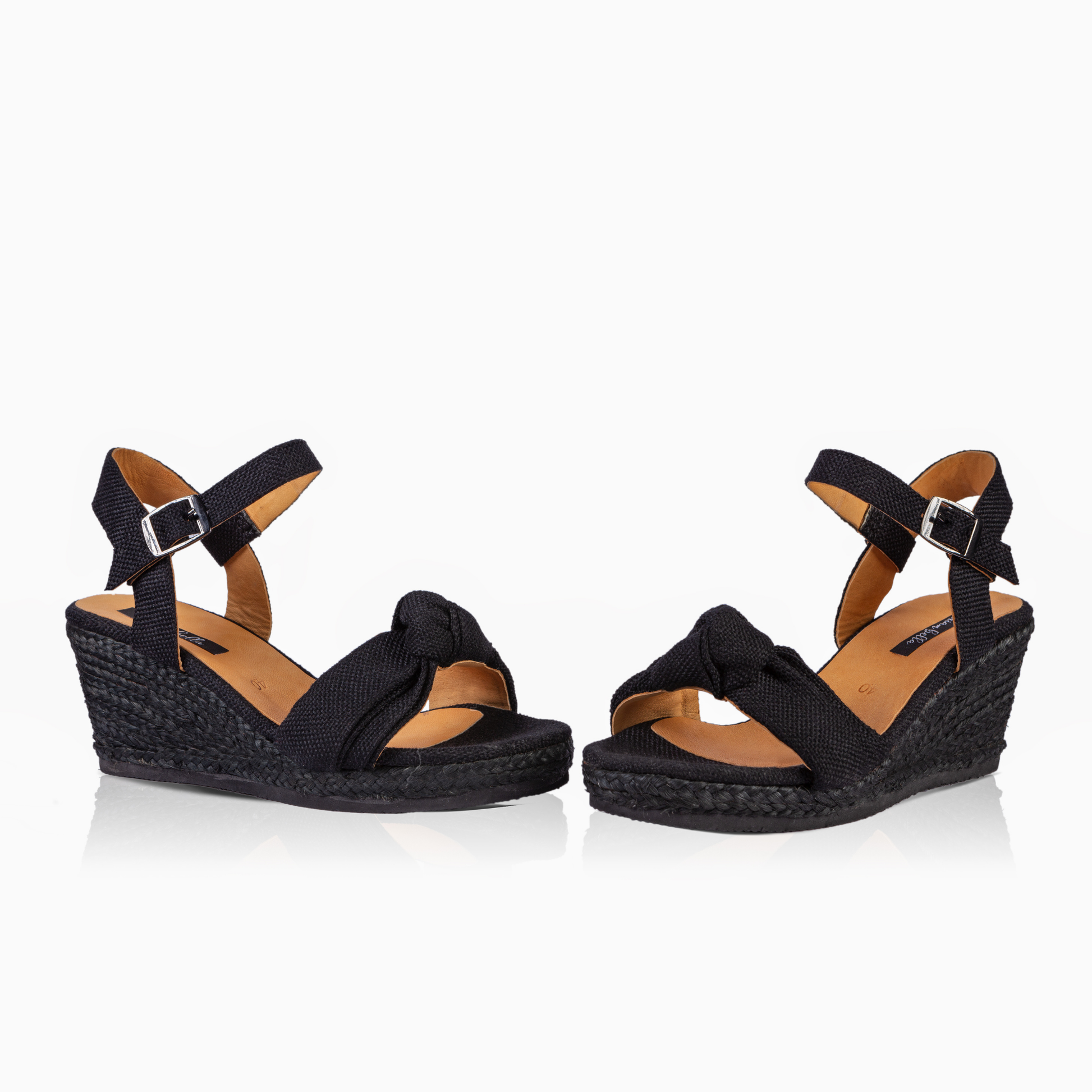 A pair of women's black wedge sandals with braided espadrille-style soles and adjustable ankle straps, shown on a clean white background.