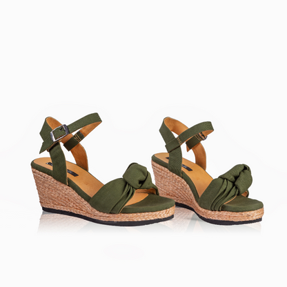 A pair of women's wedge sandals in olive green with braided jute wedge heels, tan insoles, and adjustable ankle straps with silver buckles, shown on a plain white background.