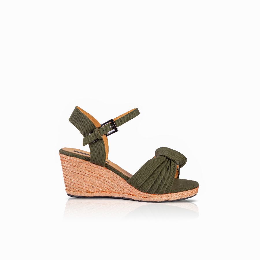 An olive green wedge sandal with an ankle strap and a knotted detail on the toe, set against a plain white background.