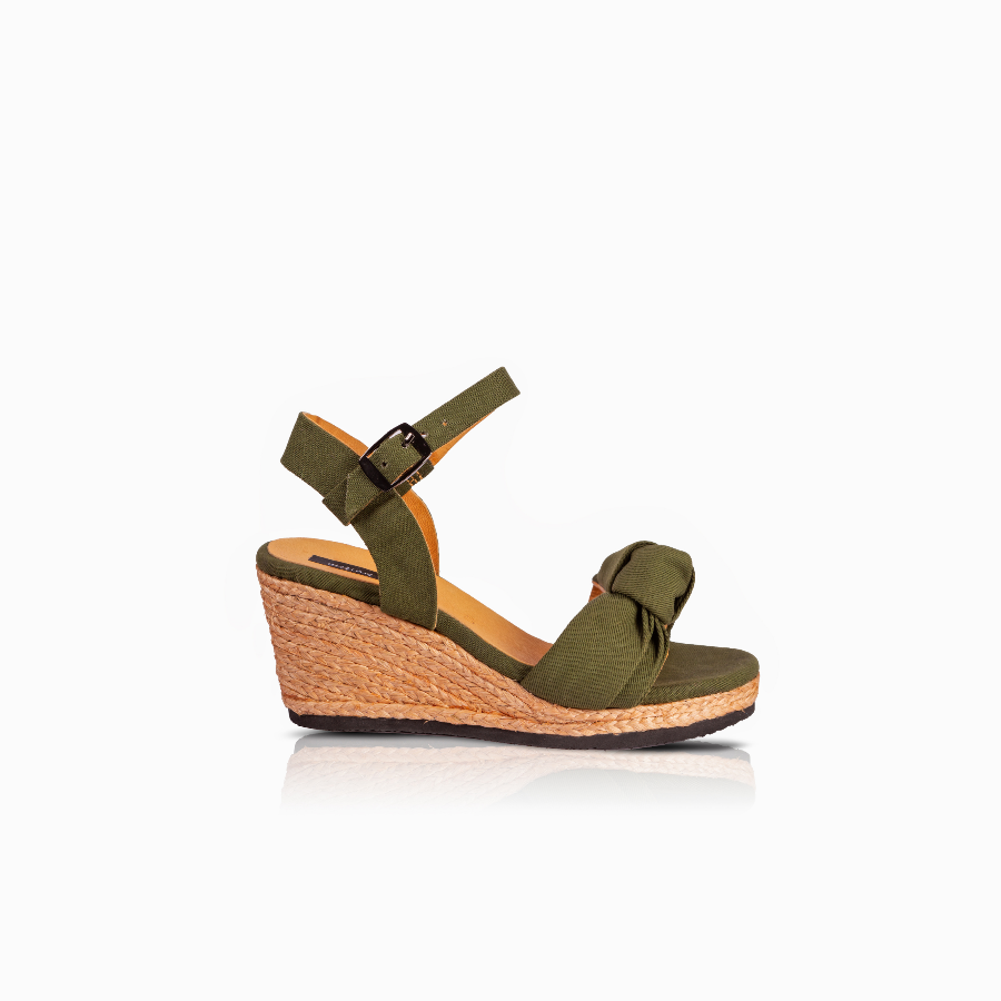 An olive green wedge sandal with an ankle strap and a knotted detail on the toe, set against a plain white background.