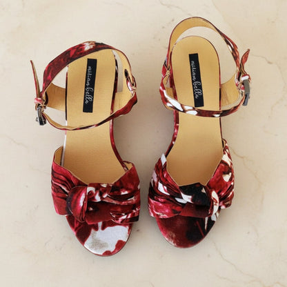 Red floral espadrille wedge sandals on a gray surface