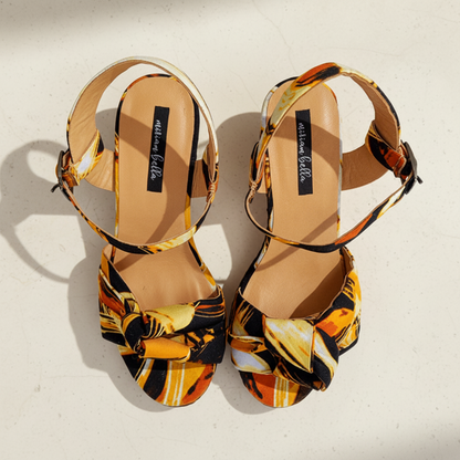 Pair of multicolored sandals with a brand label on a white background