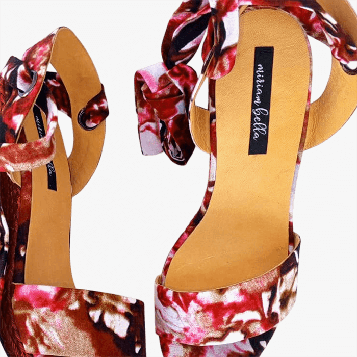 Floral high-heeled shoes with a brand label on a white background