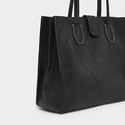 Black leather tote bag on a light gray background