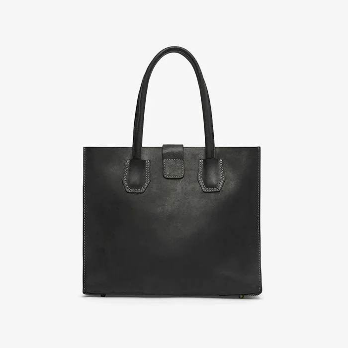 Black leather tote handbag on a light gray background