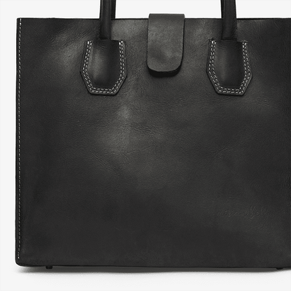 Black leather tote bag with handles on a white background