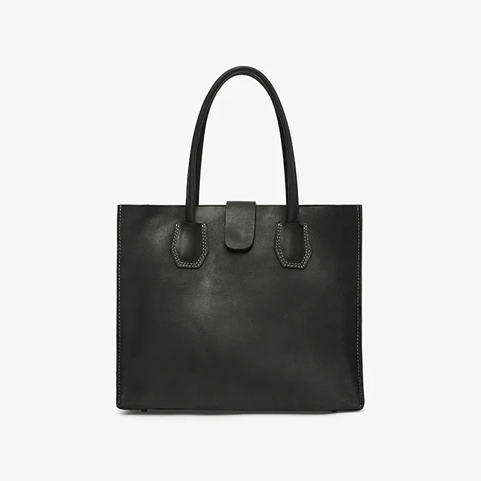 Black leather tote bag on a light gray background
