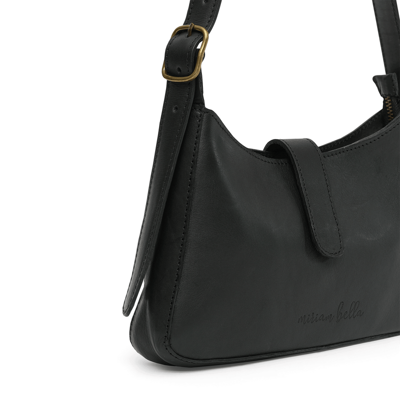 A black leather mini shoulder bag with gold buckle on a white background