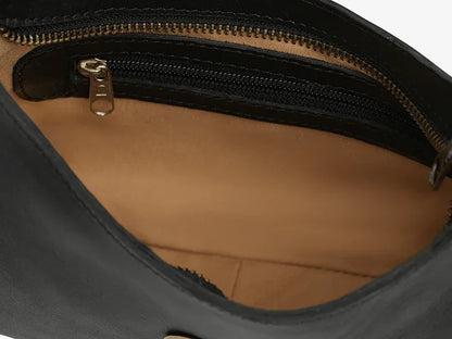 Close-up of a black leather mini shoulder bag with a zipper, showing the interior with a brown lining.