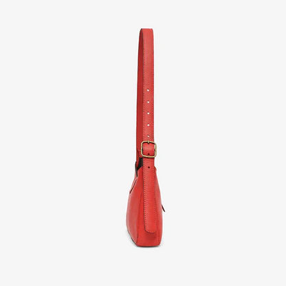A red leather mini shoulder bag with a strap on a white background