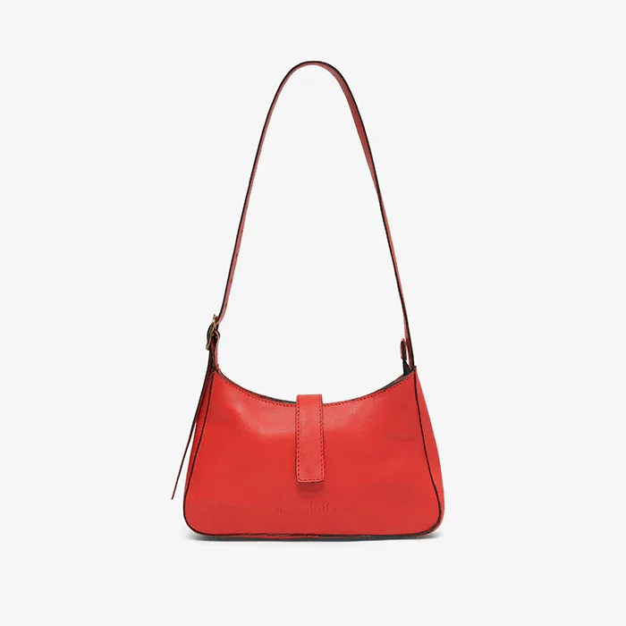 Red leather mini shoulder bag  with a strap on a light gray background
