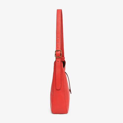 Red leather shoulder bag with a strap on a white background