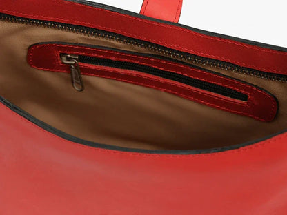Close-up of a red leather shoulder bag with brown cotton lining and a zipper.